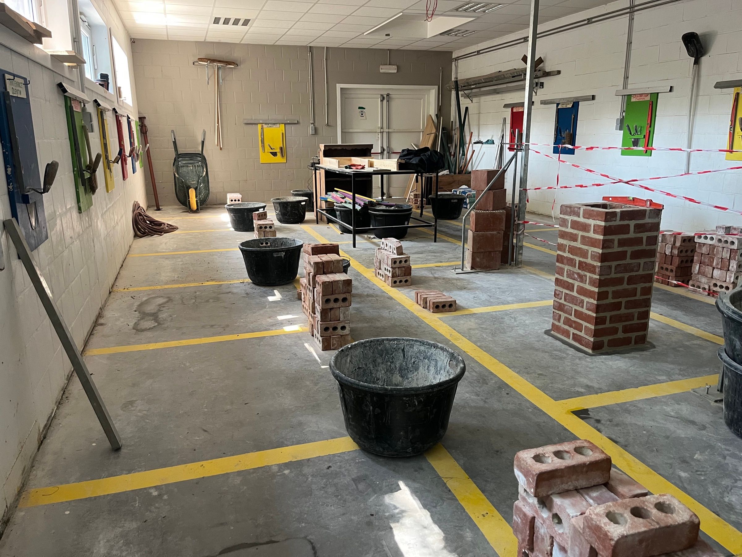 Atelier de maçonnerie, piliers de briques montés par les élèves